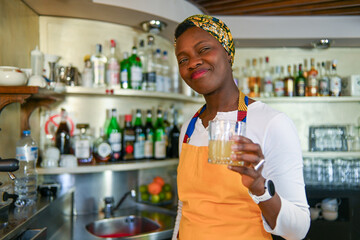 Professional african american female bartender in a vibrant headwrap and apron at work