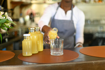Professional african american female bartender in a vibrant headwrap and apron at work