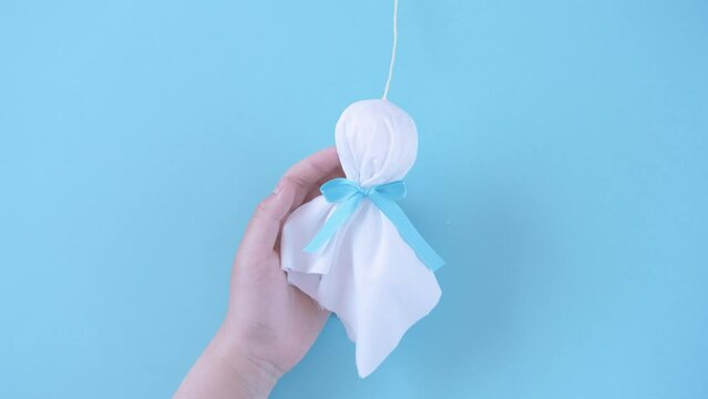 holding a little handmade doll called a teru teru bozu to wish for good weather tomorrow. てるてる坊主を持つ