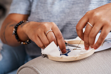 Hands, woman and embroidery with sewing at house for creative decoration design of handmade ornament as tradition. Person, designer and fabric frame canvas for cross art pattern process as hobby