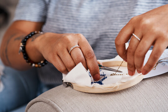 Hands, woman and embroidery with sewing at house for creative decoration design of handmade ornament as tradition. Person, designer and fabric frame canvas for cross art pattern process as hobby