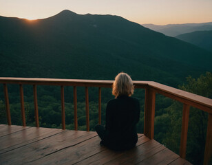 Woman Enjoying Mountain Sunset from Wooden Deck