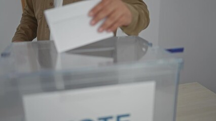 Hispanic man voting at an electoral college indoor room, showing a democratic process in action.