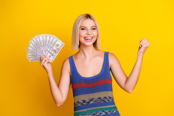 Portrait of rich person young blond lady in singlet holding banknotes dollars for win poker...