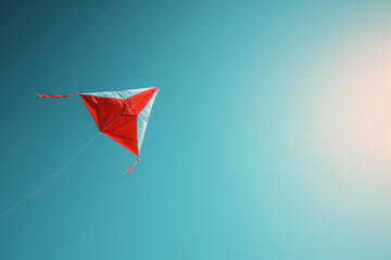 Red and blue kite flying in a clear sky, perfect for outdoor activity or freedom themes.