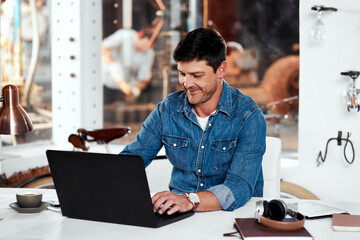 Laptop, engineering and man metal worker in workshop typing email for industrial project order. Technology, professional and male blacksmith working on computer for industry trade career in garage.