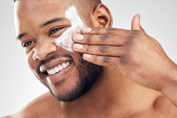 Studio, skincare and black man with cream for face or application, cosmetics and pride with smile....