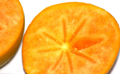 two slices of persimmon. inner part of the persimmon. sliced fruit. Orange color fruit details.