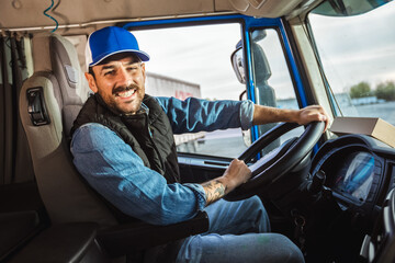 Young handsome man working in towing service and driving his truck.