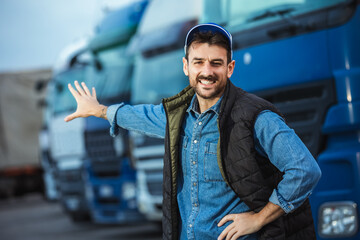 Happy confident male driver standing in front on his truck