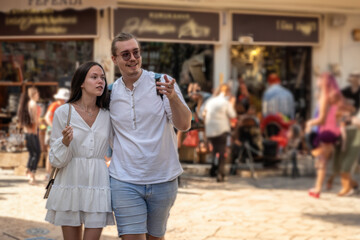 Young couple tourists walking in the ancient European city center. Explorers have trip to monument...