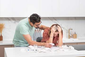 Family financial crisis concept. Shocked and stressed couple counting expenses, taxes and debts....