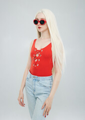 a beautiful woman in a red top and sunglasses on a white background