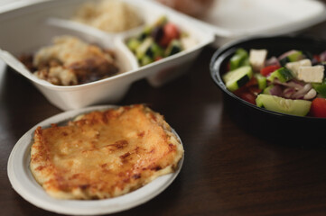 Saganaki and a Greek salad on a black table top, Greek food catering concept