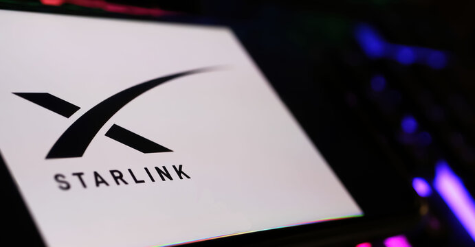 Viersen, Germany - May 9. 2024: Closeup of smartphone with logo lettering of Starlink satellite constellation on computer keyboard