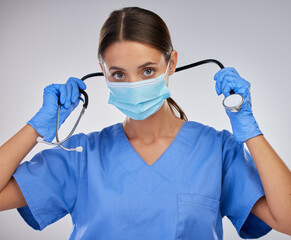 Mask, doctor and woman with stethoscope, studio and safety with gloves and PPE for healthcare. White background, medical and person with help, portrait and healthy in clinic and hands in hospital