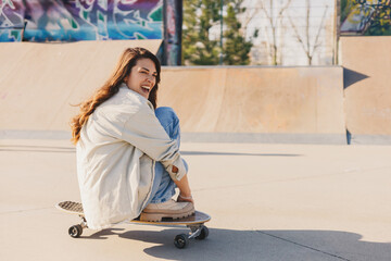 Young hipster girl on skateboard doing tricks at skate park. © Zamrznuti tonovi