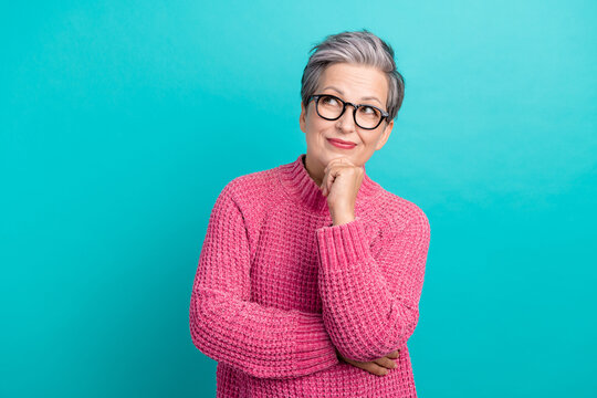 Photo of intelligent person dressed knitwear sweater in glasses thoughtfully look at offer empty space isolated on teal color background