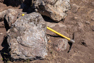 a pickaxe with a yellow plastic handle in an archaeological excavation