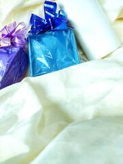 Beautiful colored present boxes with tied ribbon and cosmetic package on the tissue background....