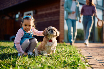 Cute girl with her dog outdoors looking at camera.