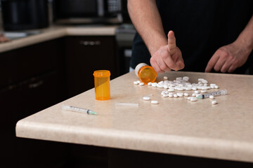 Horizontal view of person taking drugs and injection of table front him, addicted concept