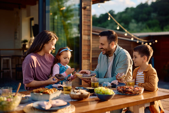 Happy family enjoying in dessert after having  lunch on their terrace.