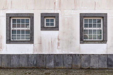 Windows on a white stucco wall.