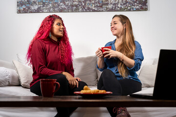 Par de amigas teniendo una charla de chicas en el sofa