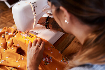Woman, sewing machine and textile production in studio or manufacturing clothes, small business or...