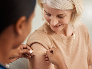 Happy, mature woman and plaster for vaccine or flu injection from nurse in clinic for health and...