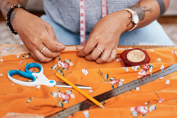 Hands, tailor and sewing cloth on table at home for manufacturing, production and handmade costume....