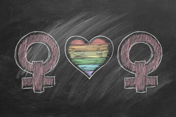 Two female gender symbols with a colorful rainbow heart, drawn in vibrant chalk on a dark chalkboard, symbolizing love, pride, and equality.