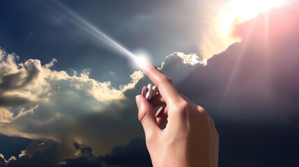 A single hand is captured touching a brilliant beam of light, giving an impression of contact with something transcendent.