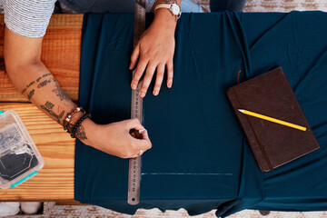 Hands, table and clothes with needle for sewing as fashion designer in studio with garment for...