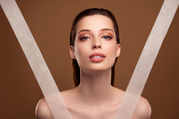 Photo of cute shiny woman nude shoulders using anti wrinkles tapes isolated beige color background