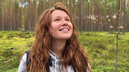 young woman in a pine forest enjoying fresh air and nature away from the city