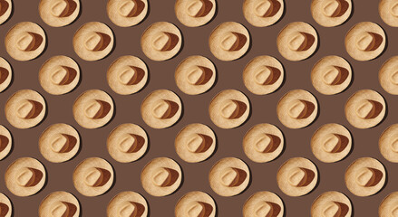 Pattern of straw with ribbon hats on brown pastel background