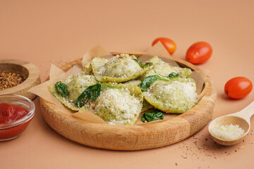 Plate of tasty ravioli with cheese on orange background