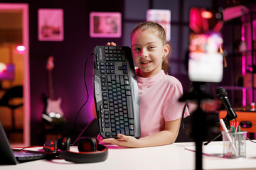 Talented cute girl enthusiastically presents latest gaming computer peripheral tech on her online...