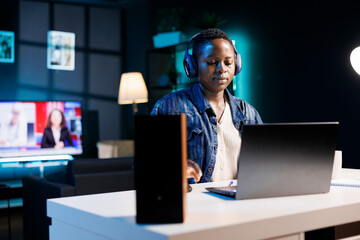 African american woman with wireless headset is attending video call meeting with clients on...