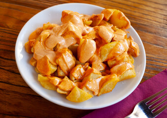 Crispy fried Patatas bravas traditionally served with spicy sauces to beer. Spanish tapa