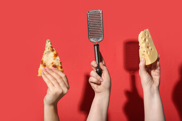 Many hands holding tasty pizza slice, grater and cheese on red background