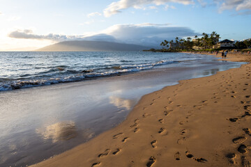 Footprints in the wet sand and people walking on the tropical paradise beach, Kamaole Beach Park II, Maui, Hawaii
