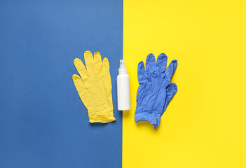 Bottle of sanitizer and rubber gloves on color background