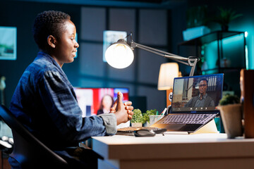 African American woman working from home, using laptop for virtual meeting with colleagues. Female...