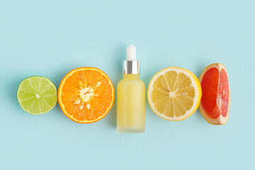 Composition with bottle of essential oil and different citrus fruits on color background