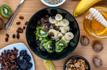 Healthy breakfast. Soaked organic raw barley, walnuts, kiwi, banana, raisins, prunes and honey on...