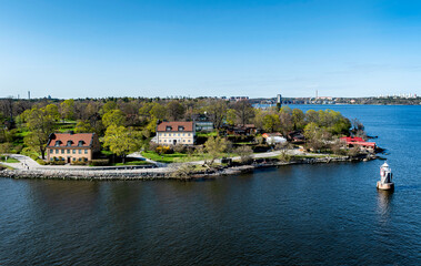 Obraz premium Rocky coast of Stockholm archipelago in Baltic sea with traditional houses at sunny spring evening scenery. 