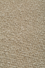 Sand-colored woven upholstery fabric texture. Close-up detail photograph.
